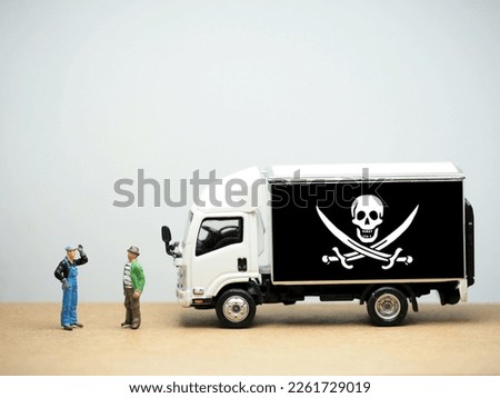 Mini toy at table with white background. Industrial shipping concept. Pirate flag design.
