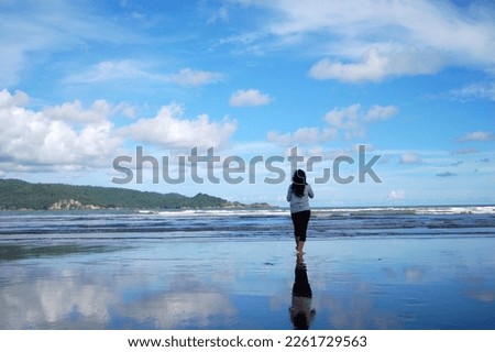 A girl standing by the beautiful beach in Pacitan, East Java, Indonesia
