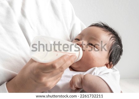 A baby who drinks milk while being held by his mother (0 years and 2 months old, Japanese, boy)