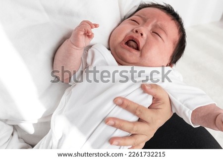 A crying baby being held by a mother (0 years and 2 months, Japanese, boy)