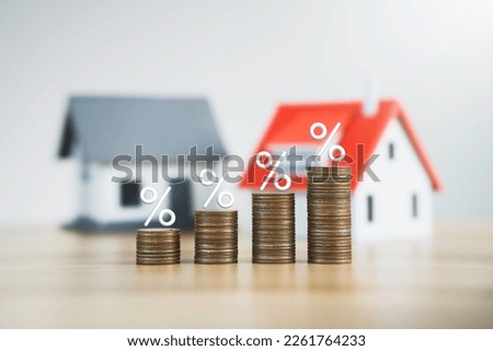 the percentage symbol for increasing interest rates on stacks of coins and the model house. Interest rates increase, home loan, mortgage, house tax. investment and asset management concept Royalty-Free Stock Photo #2261764233