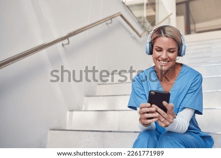 Doctor, phone and stairs for consultation, communication or video call outside hospital for health advice. Happy woman nurse smiling in healthcare with smartphone and headset for telemedicine Royalty-Free Stock Photo #2261771989