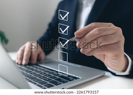 Businessman writing correct mark to approve document icon.quality management with quality assurance or QA and quality control or QC and improvement, Standardization and certification concept. Royalty-Free Stock Photo #2261793157