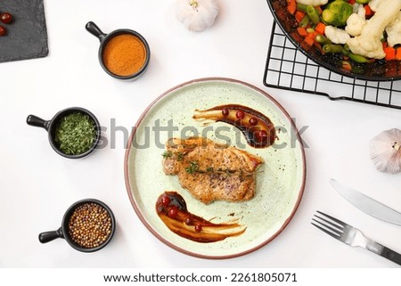 Flat lay composition with plate of delicious meat on white table in studio. Food stylist
