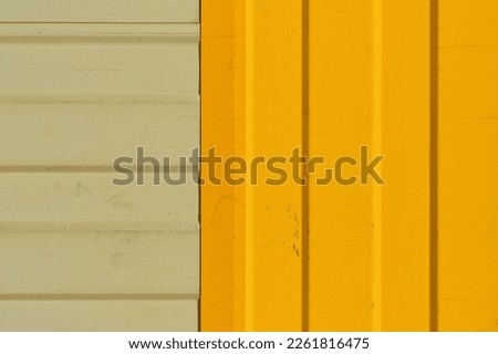Gray and bright yellow warehouse wall made of profiled metal wall, background ideas for a screen or design articles