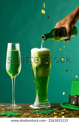 Image of beer and champagne glasses, green hat and copy space on green background. St patrick's day, irish tradition and celebration concept.