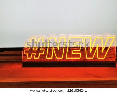 Yellow neon inscription New with hashtag. Illuminated information board. Modern sign for shop