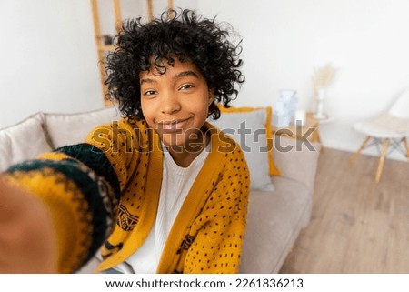 Happy african american teen girl blogger smiling face talking to webcam recording vlog. Social media influencer woman streaming making video call at home. Headshot portrait selfie webcamera view Royalty-Free Stock Photo #2261836213