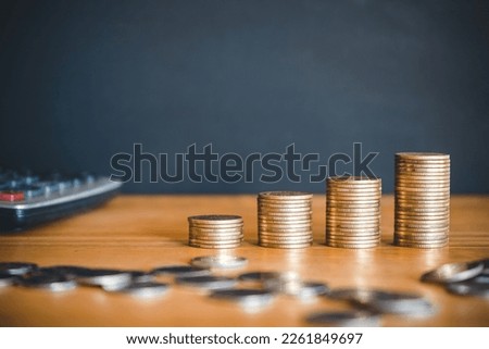 Stack of golden money coin on black background with calculator. Business and financial concept. 