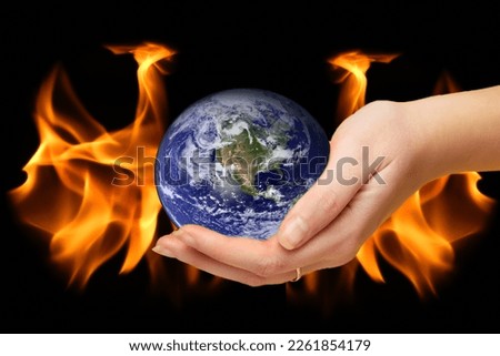 Burning world earth. Global catasrtophe concept. This image elements furnished by NASA. Apocalypse. Planet Earth in hand.