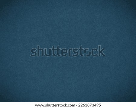 Dark blue colored paper texture. Tinted wallpaper. Textured background with vignetting. Large patterned surface. Fibers and irregularities are visible. Top-down