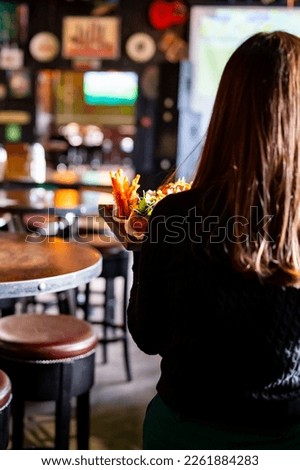 Waiter hold a plate with tasty food in restaurant Royalty-Free Stock Photo #2261884283
