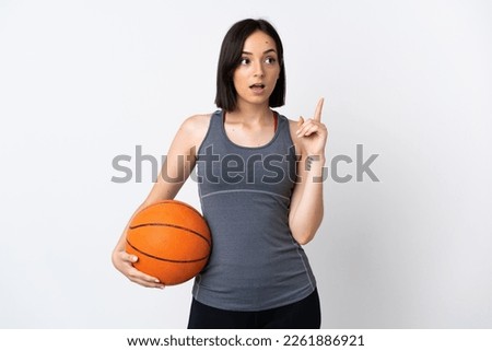 Young woman playing basketball isolated on white background thinking an idea pointing the finger up