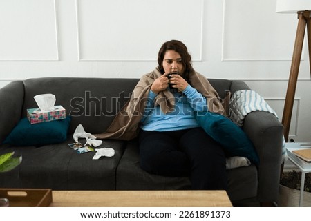 Fat young woman feeling sad and depressed drinking hot tea after crying at home because of her breakup