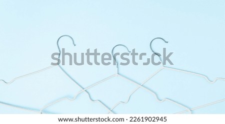Creative flat lay hangers pastel blue background. Sale discount store promo shopping concept. Top view