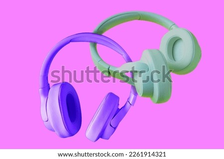 purple and green headphones fluttering on a pink background, creative photo