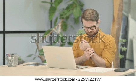 Middle Aged Businessman having Wrist Pain while using Laptop
