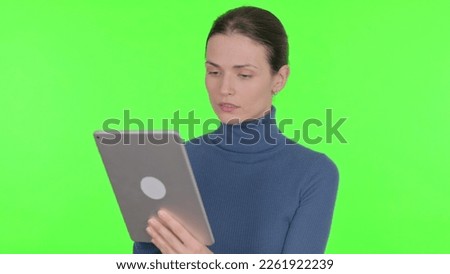 Young Woman using Digital Tablet on Green Background