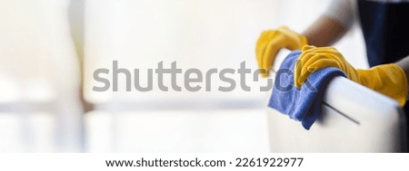 Person cleaning room, cleaning worker is using cloth to wipe computer screen in company office room. Cleaning staff. Concept of cleanliness in the organization. Royalty-Free Stock Photo #2261922977