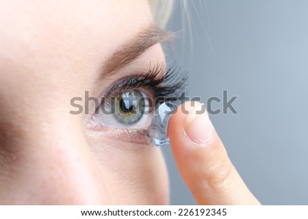 Medicine and vision concept - young woman with contact lens, close up Royalty-Free Stock Photo #226192345