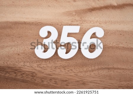 White number 356 on a brown and light brown wooden background.