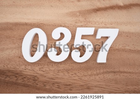 White number 0357 on a brown and light brown wooden background.