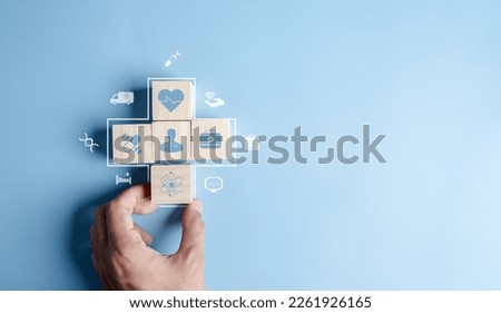 Health insurance concept. people hands putting plus symbol and healthcare medical wooden cube block with icon, health and access to welfare health concept Royalty-Free Stock Photo #2261926165
