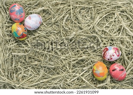 Easter composition with colored chicken eggs on a straw background. Easter party concept with empty space. View from above.