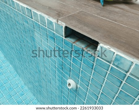 Water outlet in a swimming pool. Blue mosaic tile. High angle shot. Selective focus. Swimming pool design concept.