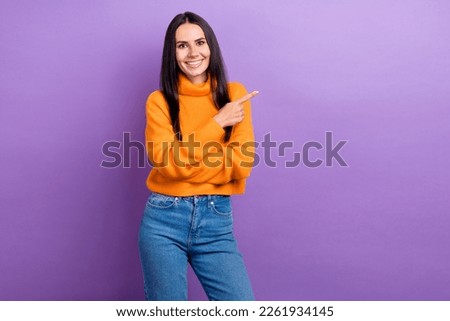 Photo of young positive woman wear orange pullover denim jeans direct finger mockup proposition cheap clothes isolated on violet color background