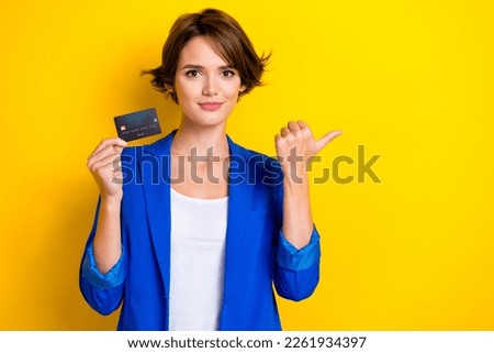 Photo of young promoter beautiful lady wear trendy outfit hold debit card save money direct thumb mockup banking isolated on yellow color background