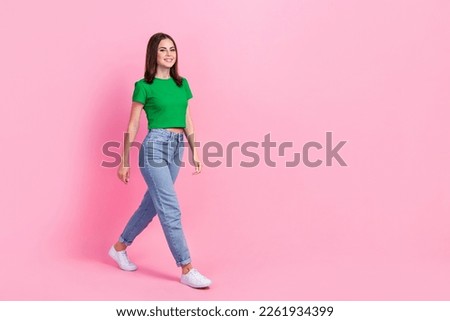Full length photo of adorable sweet girl wear green crop top looking walking empty space isolated pink color background