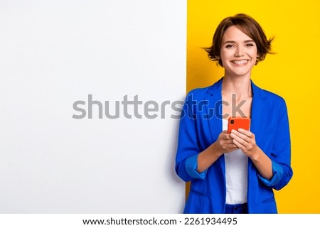 Photo of sweet cute woman wear blue jacket chatting instagram twitter white wall poster empty space isolated yellow color background