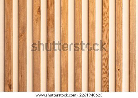 narrow wooden slats on a white plastered wall as an element of modern decor in a minimalistic interior design Royalty-Free Stock Photo #2261940623