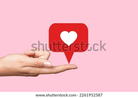 Hand hold a heart sign on pink background