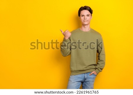 Portrait of satisfied nice person direct thumb finger empty space blank isolated on yellow color background