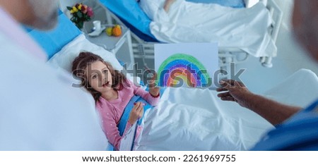 Little girl in hospital room drew a nice picture of rainbow, concpet of healing and hope.