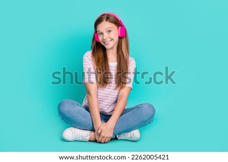 Full length photo of funny dreamy lady wear striped t-shirt enjoying songs headphones isolated turquoise color background