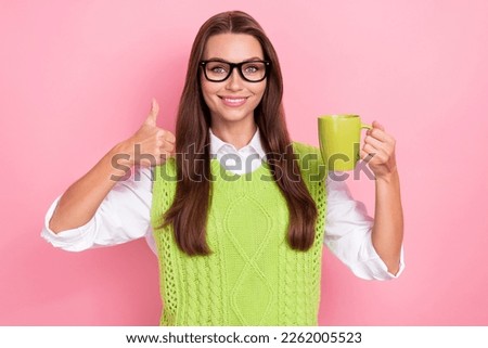 Photo of optimistic cheerful nice girl straight hairstyle dressed green vest showing okey hold cup isolated on pink color background