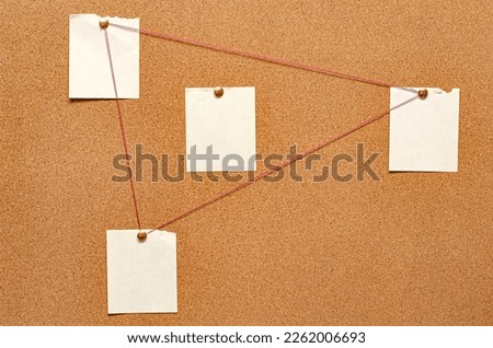 Blank paper notes are pinned to a cork board. The concept of detective investigation. Copy space. Royalty-Free Stock Photo #2262006693