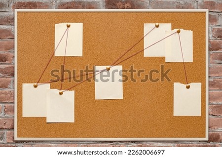 Blank paper notes are pinned to a cork board. The concept of detective investigation. Copy space. Royalty-Free Stock Photo #2262006697