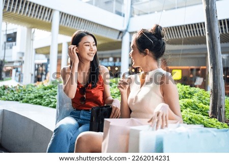 Asian young two woman shopping goods outdoors in department store. Beautiful female friend holding shopping bags then walk together with happiness enjoy purchasing in department store or shopping mall Royalty-Free Stock Photo #2262014231