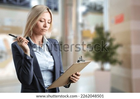 Cheerful young person using a clip board Royalty-Free Stock Photo #2262048501