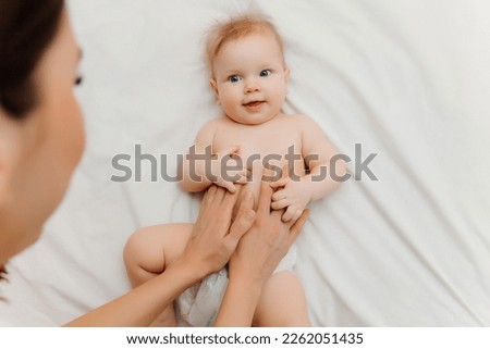 Baby tummy massage. woman's hands do massage of baby's tummy.