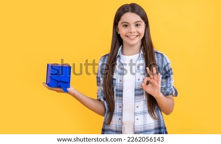 photo of teen girl with birthday gift box, ok. teen girl with birthday gift isolated on yellow.