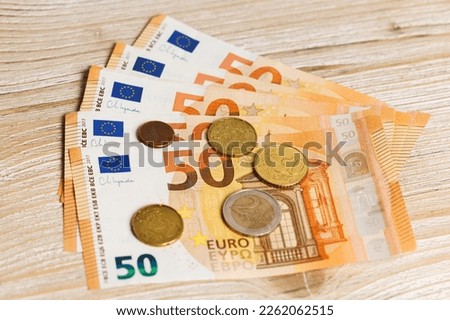 Euro bills and coins on a wooden table Royalty-Free Stock Photo #2262062515