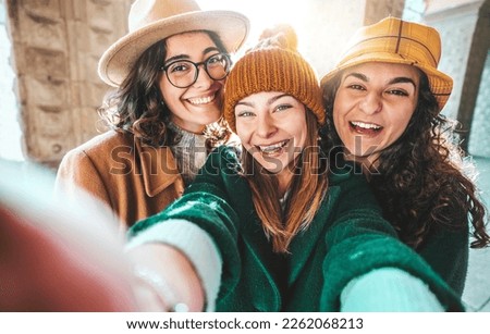Three beautiful young women taking selfie on city street - Cheerful female friends having fun hanging out on sunny day - Life style concept with girls laughing together at camera Royalty-Free Stock Photo #2262068213