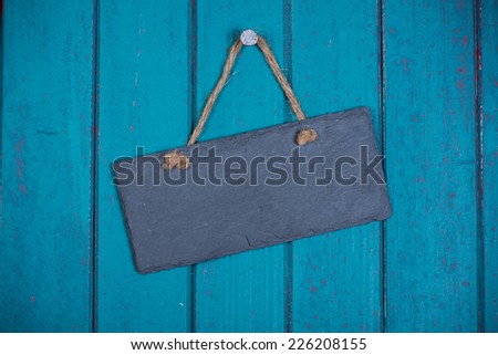Stone signboard with rope hanging on wooden background