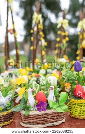 Easter decoration wicker basket sold at a fair in the Czech Republic, traditional spring flowers - tulip, primrose, daisy, golden rain and goose and red Easter egg decoration