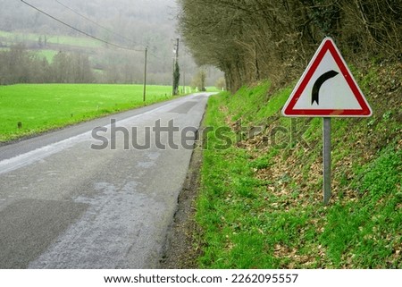 Road and road sign warning about a turn in the road. Road safety concept.  